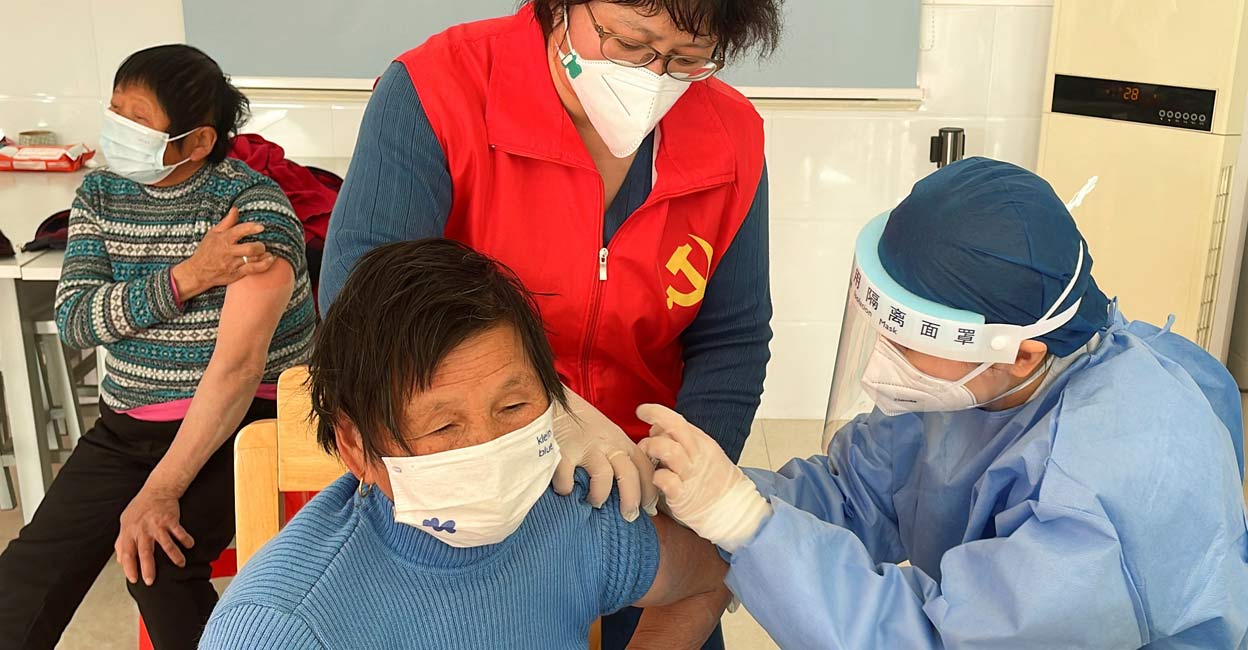 HEALTH-CORONAVIRUS-CHINA-VACCINATION A medical worker administers a dose of a vaccine against coronavirus disease (COVID-19) to an elderly resident, during a government-organized visit to a vaccination center in Zhongmin village on the outskirts of Shanghai, China December 21, 2022. REUTERS/Brenda Goh
