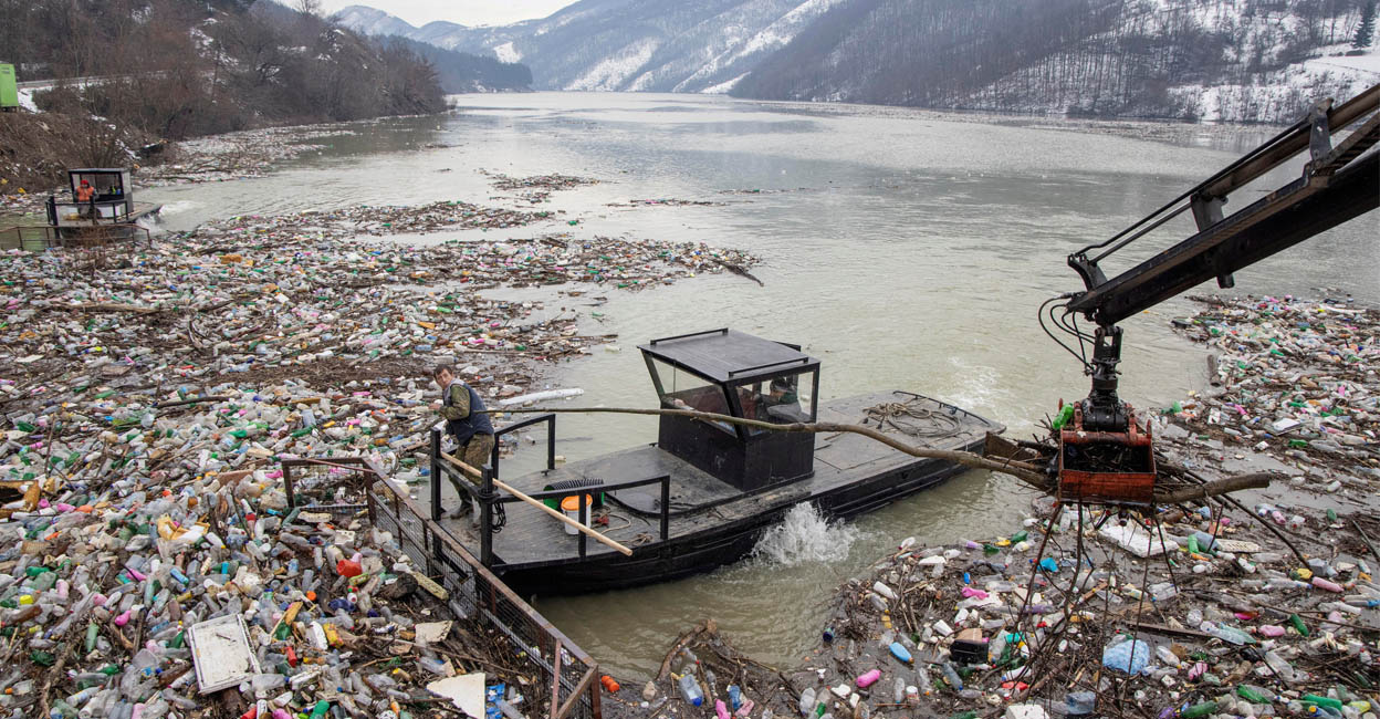 plastic-add A worker collects plastic trash that litters the polluted Potpecko Lake near a dam's hydroelectric plant near the town of Priboj, Serbia. Photo: REUTERS/Marko Djurica