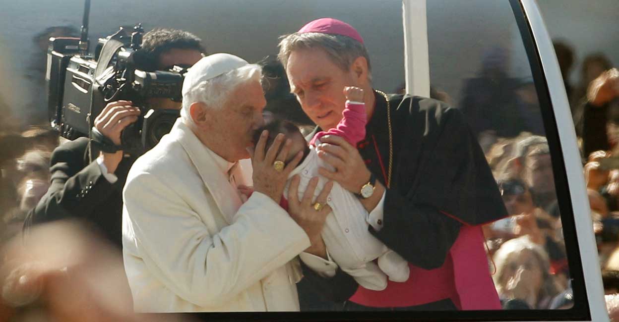 POPE-BENEDICT-OBITUARY Pope Benedict XVI blesses a baby as he rides around St Peter's Square to hold his last general audience at the Vatican on February 27, 2013. Photo: Reuters