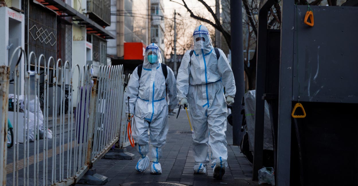 Pandemic prevention workers in protective suits walk in a street as coronavirus disease (COVID-19) outbreaks continue in Beijing :REUTERS/Thomas Peter