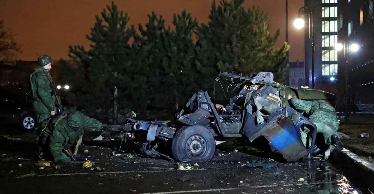 Specialists inspect a wreckage of a car that, according to the local authorities, was blown up near the government building, in the rebel-controlled city of Donetsk, Ukraine February 18, 2022. REUTERS/Alexander Ermochenko