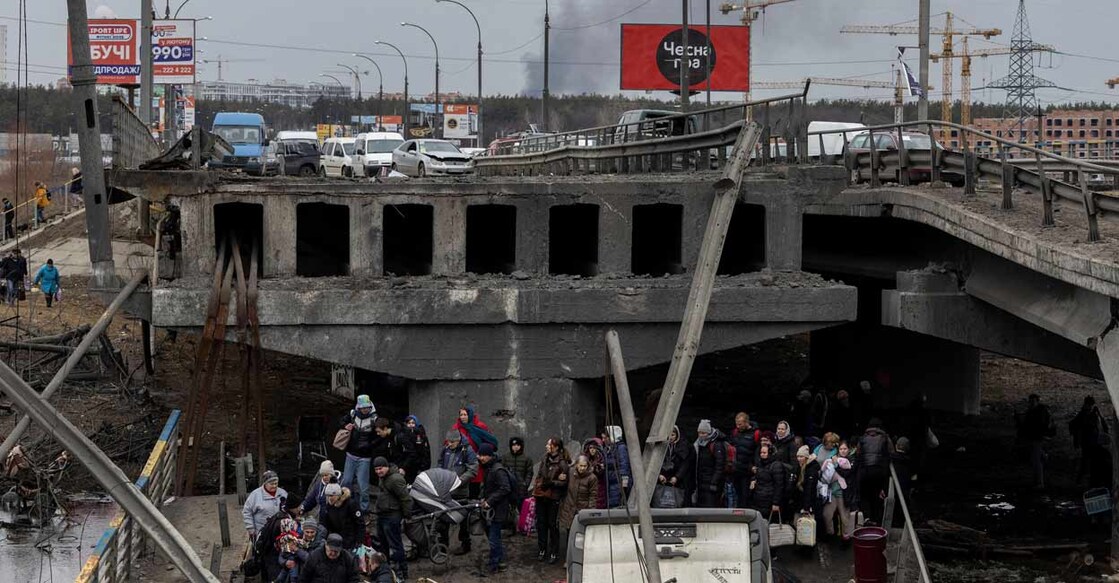 Local residents cross a destroyed bridge as they evacuate from the town of Irpin, after days of heavy shelling on the only escape route used by locals, while Russian troops advance towards the capital, in Irpin, near Kyiv, Ukraine March 7, 2022. Photo: Reuters/Carlos Barria