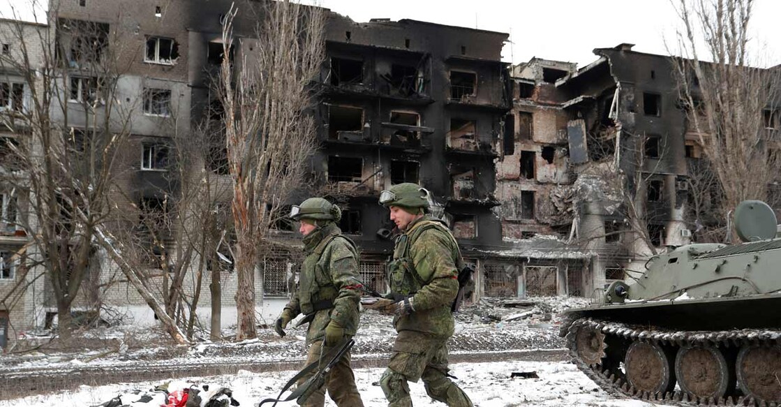 Service members of pro-Russian troops in uniforms without insignia walk near a residential building which was heavily damaged during Ukraine-Russia conflict in the separatist-controlled town of Volnovakha in the Donetsk region, Ukraine March 11, 2022. Photo: Alexander Ermochenko/Reuters