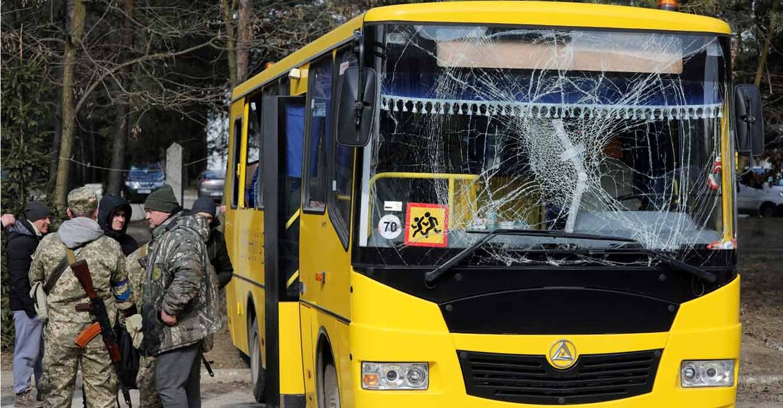 FILE PHOTO: Servicemen stand next to a bus with a damaged windscreen, following an attack on the Yavoriv military base, amid Russia's invasion of Ukraine, in Novoyavorivsk, Ukraine, March 13, 2022. REUTERS/Roman Baluk