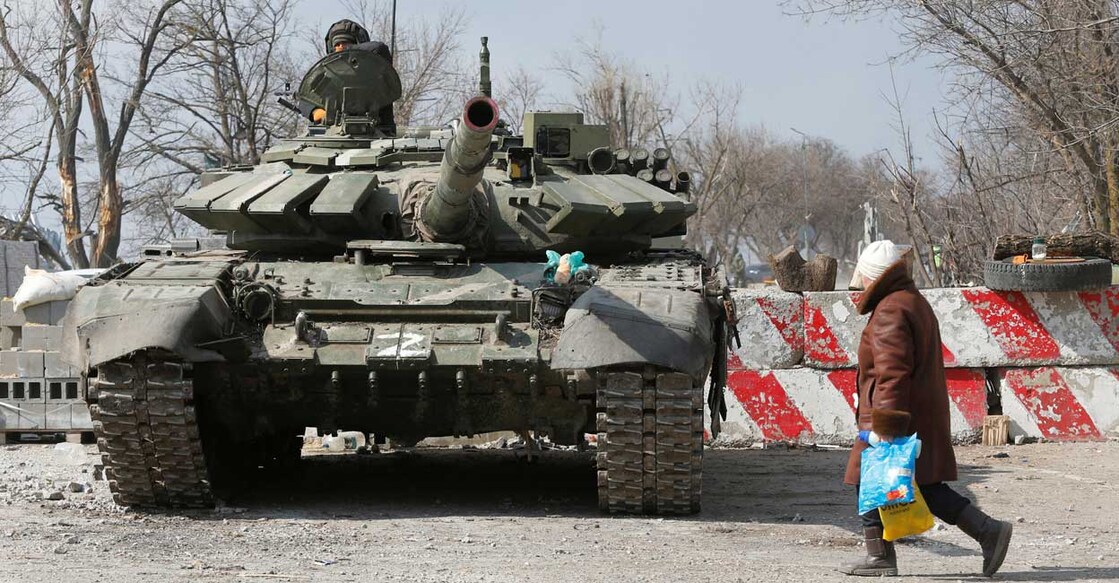 A local resident walks past a tank of pro-Russian troops during Ukraine-Russia conflict in the besieged southern port city of Mariupol, Ukraine March 18, 2022. Reuters/Alexander Ermochenko