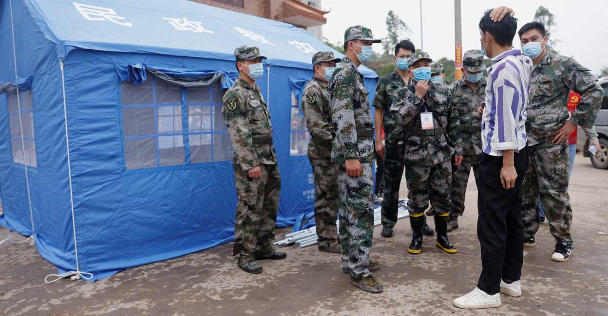 China Eastern Airlines Militia members speak with a manager at the entrance of Lu village near the site where a China Eastern Airlines Boeing 737-800 plane flying from Kunming to Guangzhou crashed, in Wuzhou, Guangxi Zhuang Autonomous Region, China March 22, 2022. Photo: Reuters/Carlos Garcia Rawlins