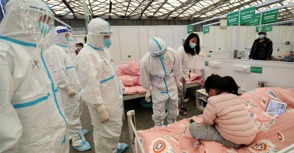 Medical workers in protective suits check a child patient as they conduct ward rounds at Shanghai New International Exhibition Hall, which has been turned into a makeshift hospital for the coronavirus disease (COVID-19), in Shanghai. Photo: Reuters 