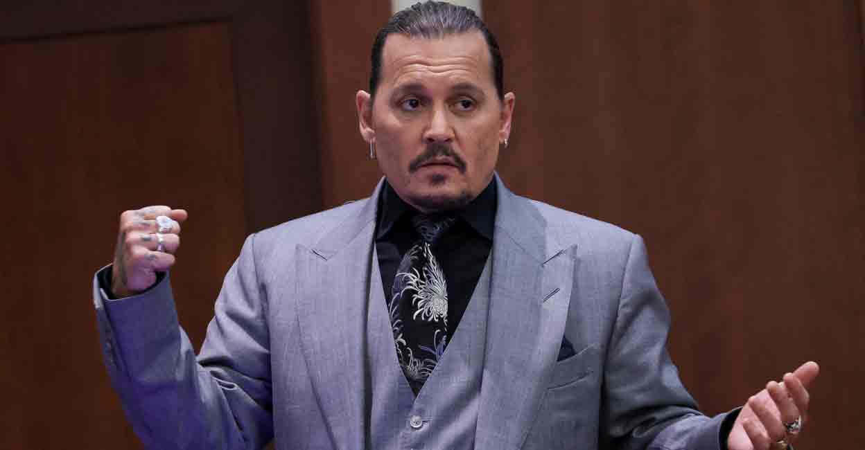 Actor Johnny Depp demonstrates what he claims was an alleged attack by his ex-wife Amber Heard as he testifies during his defamation trial against Heard, at the Fairfax County Circuit Courthouse in Fairfax, Virginia, U.S., April 20, 2022. REUTERS/Evelyn Hockstein/Pool