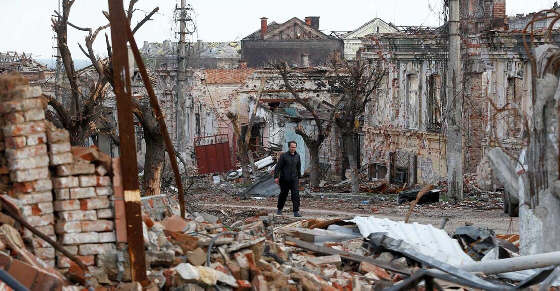 A man walks near damaged buildings in the course of Ukraine-Russia conflict in the southern port city of Mariupol, Ukraine April 22, 2022. Reuters/Alexander Ermochenko