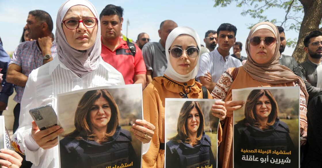Palestinians hold pictures of Al Jazeera reporter Shireen Abu Akleh, who was killed by Israeli army gunfire during an Israeli raid, according to the Qatar-based news channel, in Nablus in the Israeli-occupied West Bank May 11, 2022. Israeli military said Abu Akleh may have been shot by Palestinians as they clashed with its troops. PHOTO: Reuters/Raneen Sawafta