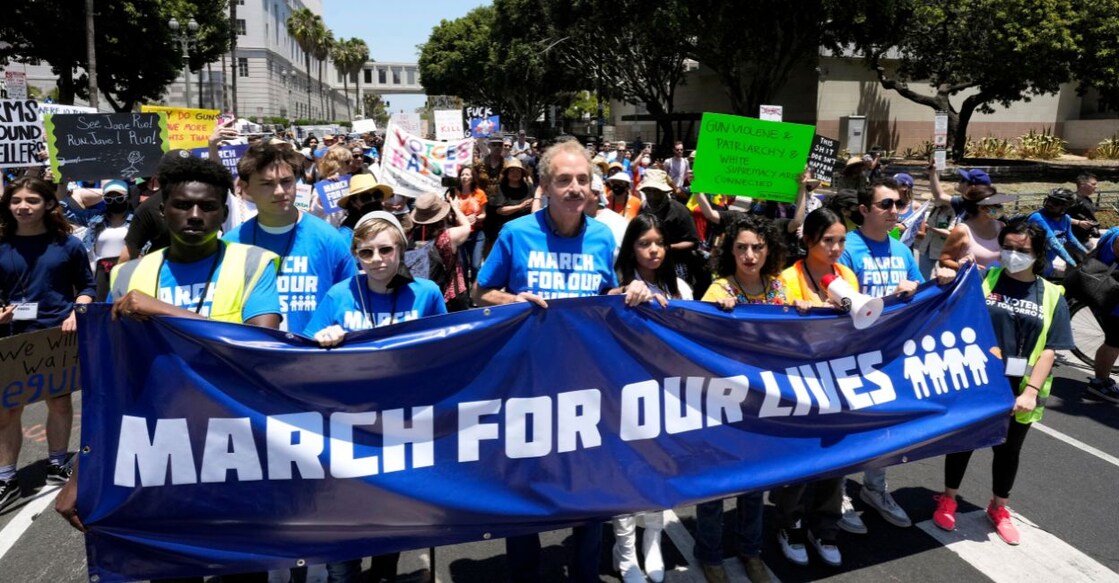 Los Angeles City Attorney and former mayoral candidate Mike Feuer, center, marches along with protestors as they chant and wave signs in downtown Los Angles during a March for Our Lives rally, Saturday, June 11, 2022. PHOTO: AP