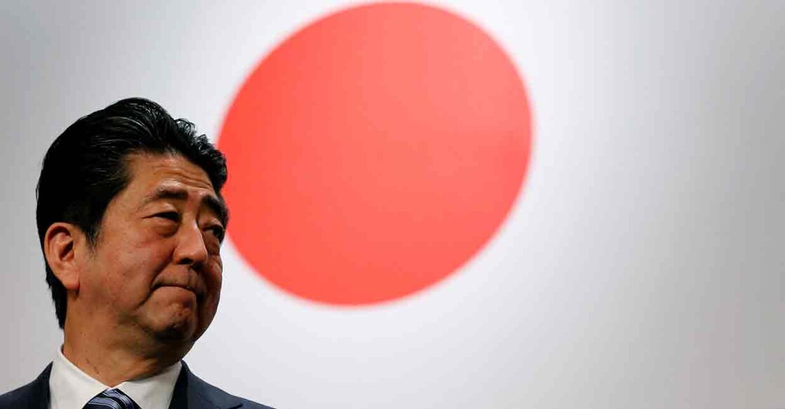 FILE PHOTO: Japan's former Prime Minister Shinzo Abe stands in front of Japan's national flag after his ruling Liberal Democratic Party's (LDP) annual party convention in Tokyo, Japan, March 5, 2017. REUTERS/Toru Hanai