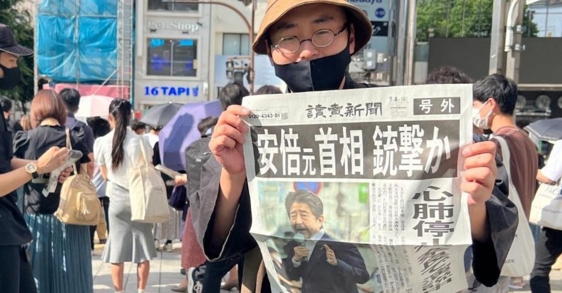 shinzo-abe-dead A man shows an extra edition of the Yomiuri Shimbun newspaper reporting on the shooting of former Japanese Prime Minister Shinzo Abe, on a street in Tokyo, Japan, July 8, 2022. PHOTO: IANS