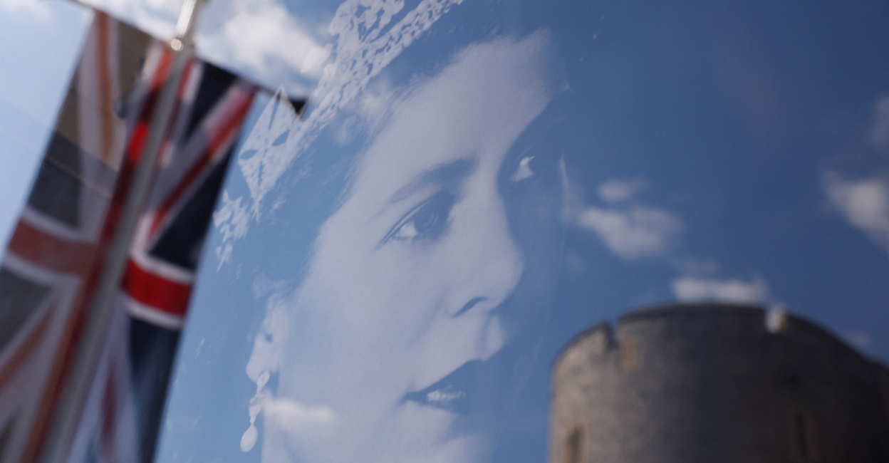 BRITAIN-ROYALS-QUEEN A Union Jack flag outside Windsor Castle is reflected on an image of Britain's Queen Elizabeth, following the death of the queen, in Windsor, Britain, September 17, 2022. File photo: REUTERS/Andrew Couldridge