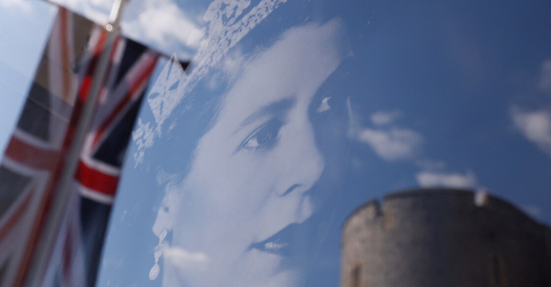 A Union Jack flag outside Windsor Castle is reflected on an image of Britain's Queen Elizabeth, following the death of the queen, in Windsor, Britain, September 17, 2022. File photo: REUTERS/Andrew Couldridge