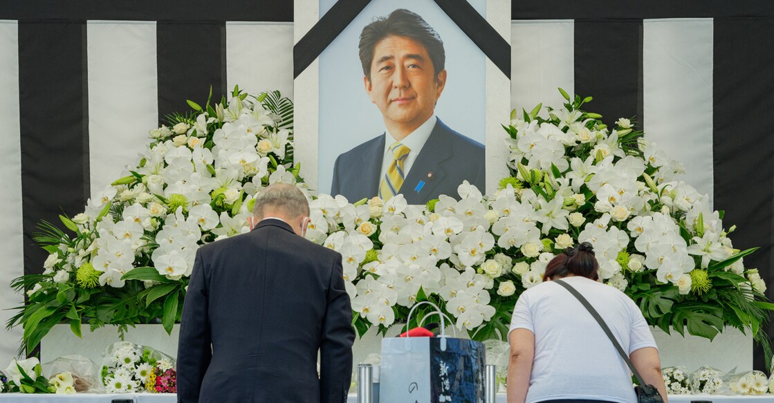 People leave flowers and pay their respects to former Japanese prime minister Shinzo Abe outside the Nippon Budokan in Tokyo on September 27, 2022, ahead of his state funeral later in the day. Thousands of Japanese and foreign dignitaries have gathered in Tokyo on September 27 to honour Abe, at a rare state funeral that has sparked controversy and protest. Photo: Nicolas Datiche/Pool via REUTERS