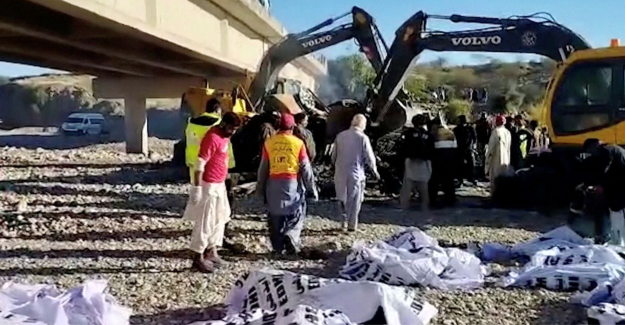 Bodies of victims lie in bags as people work at the site of a bus crash in Lasbela District, Balochistan province, Pakistan January 29, 2023. Photo: Reuters