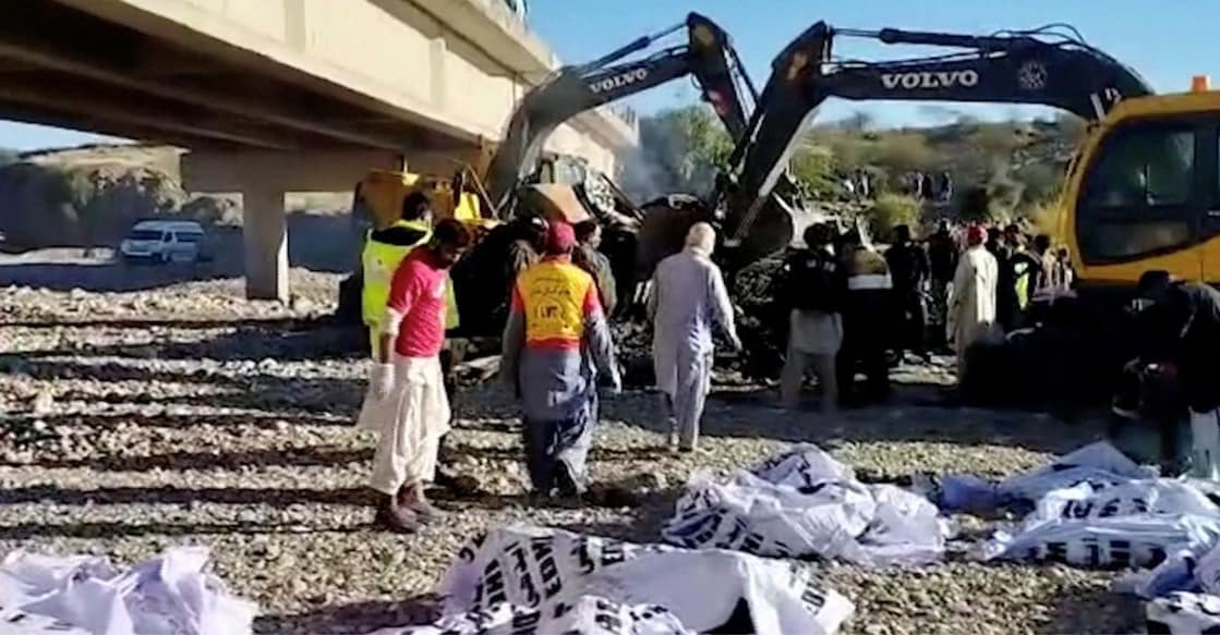 Bodies of victims lie in bags as people work at the site of a bus crash in Lasbela District, Balochistan province, Pakistan January 29, 2023. Photo: Reuters