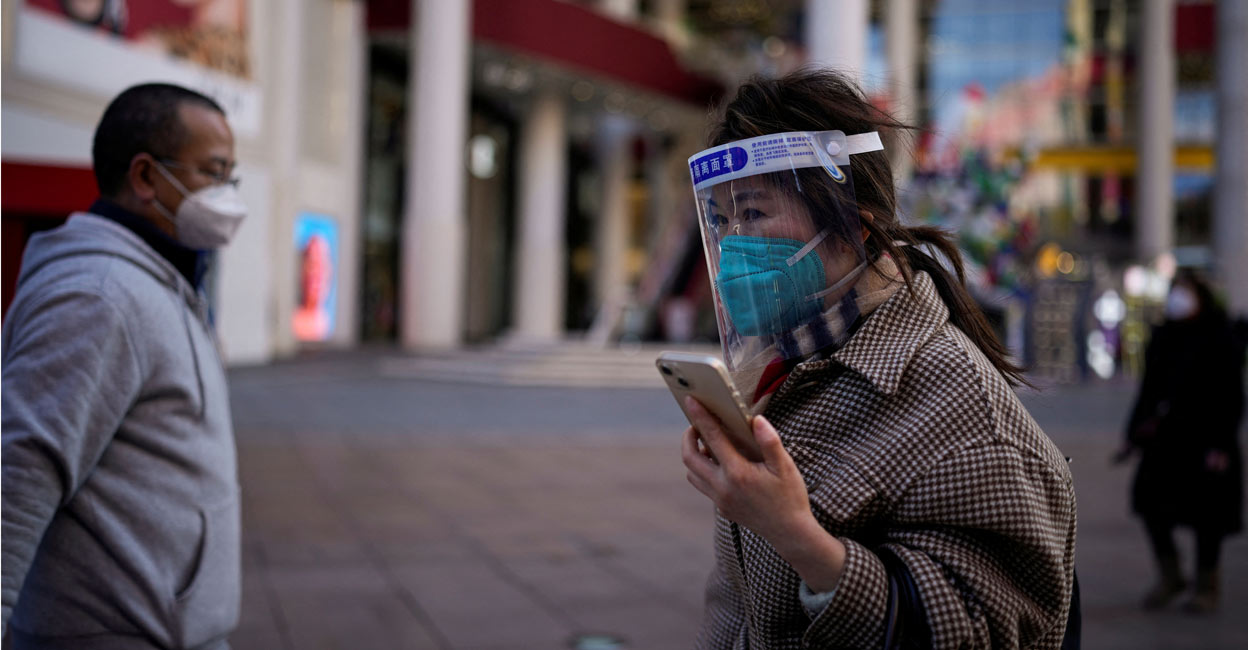 A woman wearing a protective mask and a face shield walks along in a shopping district as China returns to work despite continuing coronavirus disease (COVID-19) outbreaks in Shanghai, China, January 3, 2023. REUTERS/Aly Song