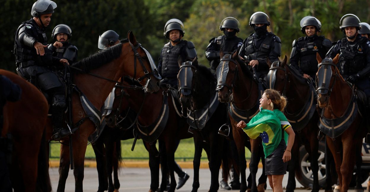 brazil-1 A demonstrator reacts next to members of security forces as supporters of Brazil's former President Jair Bolsonaro leave a camp outside the Army Headquarters, in Brasilia, Brazil, January 9, 2023. Photo: Reuters