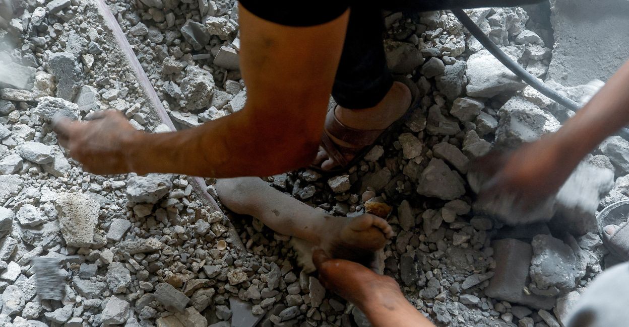 Palestinians work to pull the dead body of a girl from under the rubble of the municipality building which was hit by Israeli strikes in Khan Younis, in the southern Gaza Strip on Tuesday. The girl was taking shelter with her family in the building after they fled their home due to the strikes. Photo: Reuters/Ibraheem Abu Mustafa