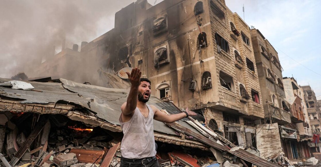 A man reacts outside a burning collapsed building following Israeli bombardment in Gaza City. Photo: AFP