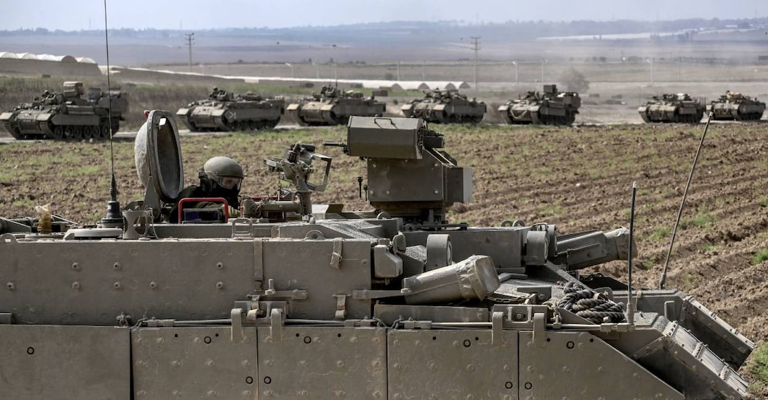 An Israeli army soldier sits in the hatch of a Puma armoured personnel carrier (APC) in a column with other vehicles near the Gaza border in southern Israel. Photo: AFP