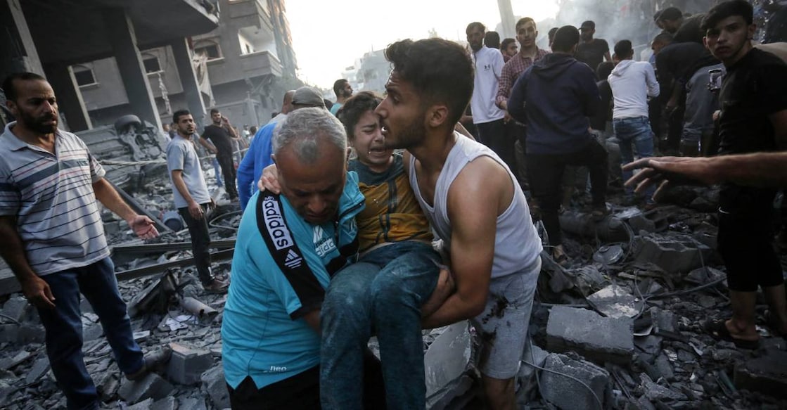 Men carry away an injured girl following an Israeli strike on the town of Deir Al-Balah in the central Gaza Strip . Photo: AFP
