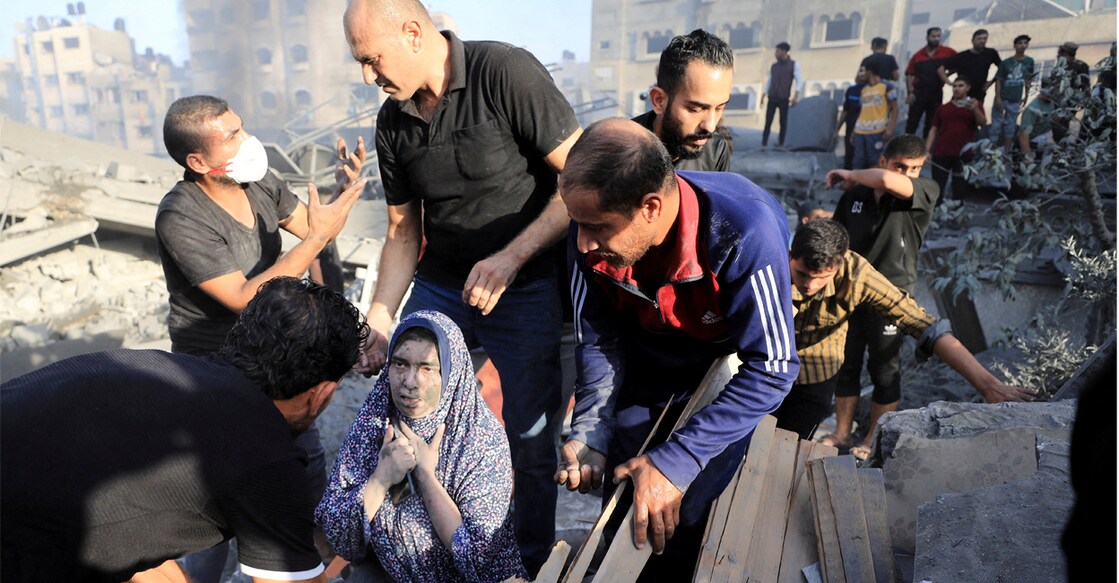 A Palestinian woman is assisted, as people search for casualties at the site of an Israeli strike on a residential building in Gaza City on Wednesday. Photo: REUTERS/Yasser Qudih