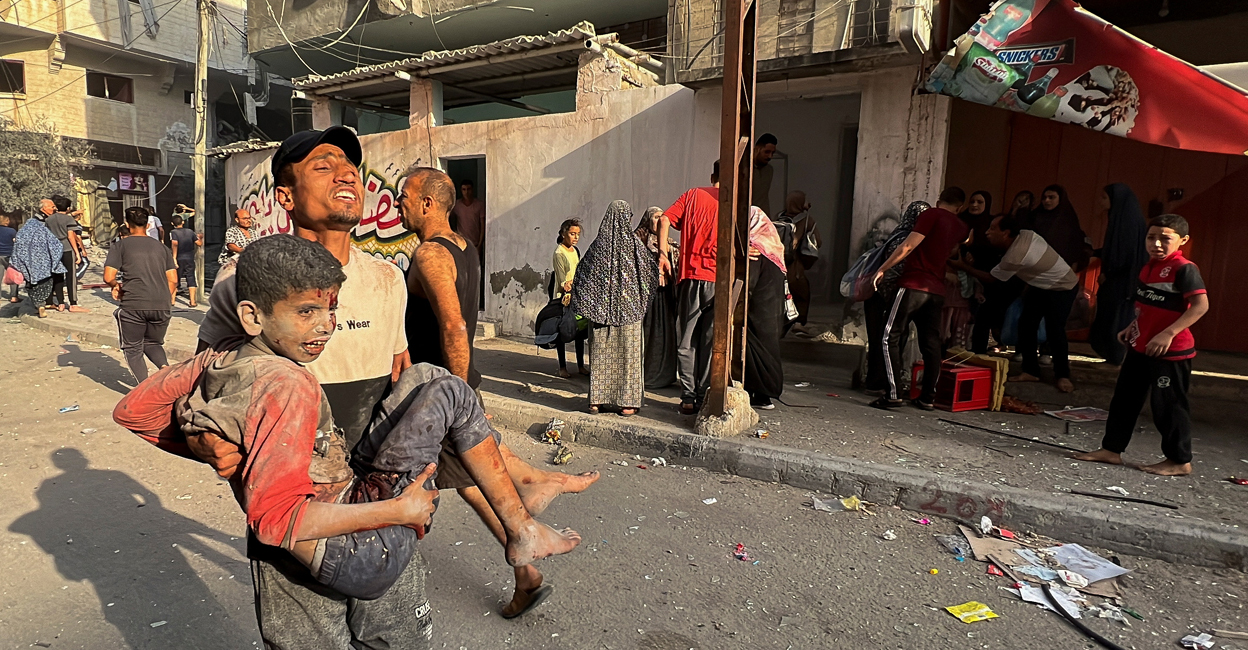 ISRAEL-PALESTINIANS A Palestinian carries a child casualty at the site of Israeli strikes on houses, in Gaza City. Photo: Reuters