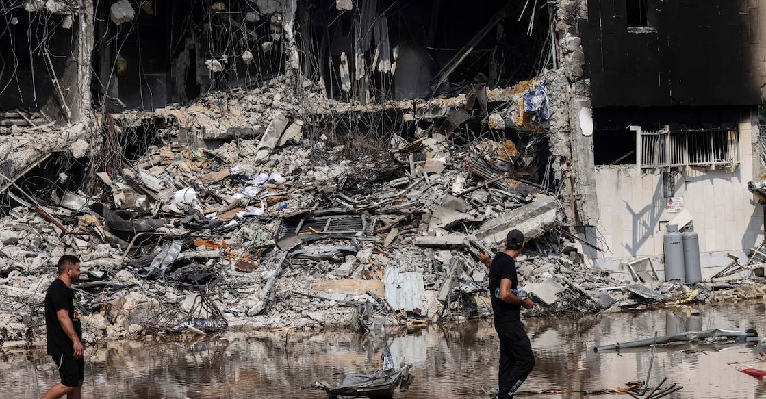 People walk past an Israeli police station in Sderot after it was damaged during battles to dislodge Hamas militants who were stationed inside, on October 8, 2023. Photo: Ronaldo Schemidt/AFP