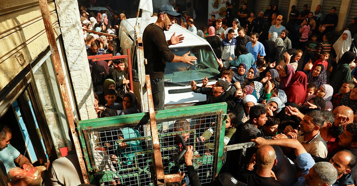 Palestinians queue as they wait to buy bread from a bakery, amid shortages of food supplies and fuel. Photo: Reuters