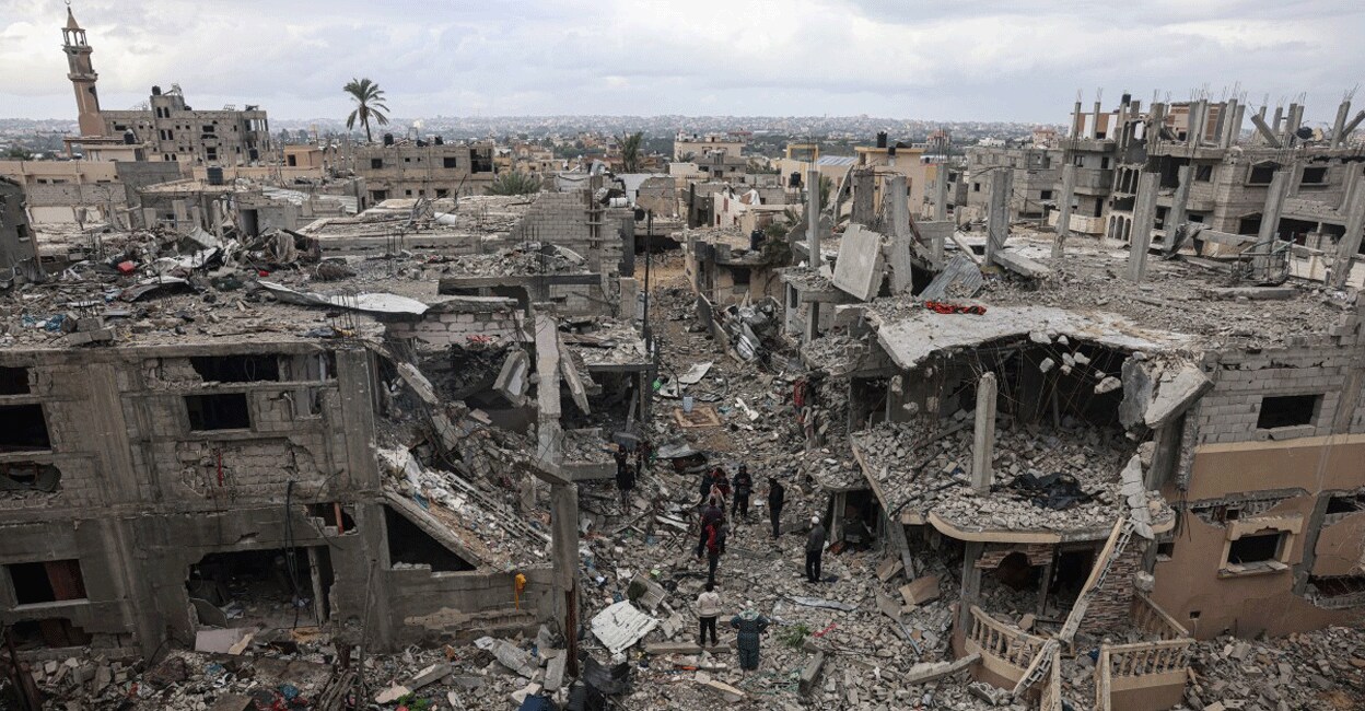 PALESTINIAN-ISRAEL-CONFLICT Palestinians inspect the destruction caused by Israeli strikes on their homes in the village of Khuzaa, east of Khan Yunis near the border fence between Israel and the southern Gaza Strip on November 27, 2023, amid a truce in battles between Israel and the Palestinian militant group Hamas. Photo: AFP/ Said Khatib