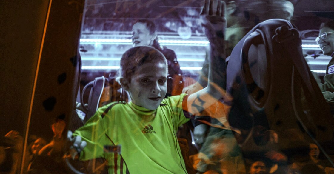 Hostage released by Hamas Tal Almog-Goldstein (left) stands in a bus transporting him to an army base in Ofakim in southern Israel after he was released by the Palestinian militant group from the Gaza Strip on November 26, 2023. Photo: AFP/ Menahem Kahana