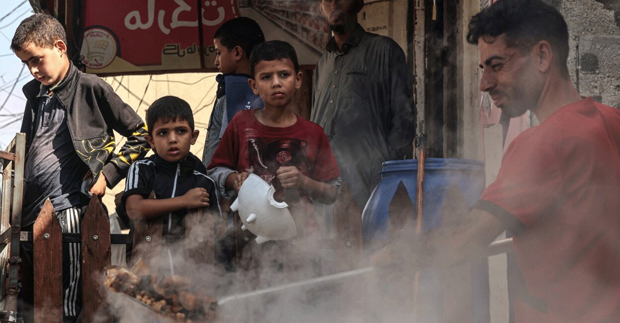 PALESTINIAN-ISRAEL-GAZA-CONFLICT Palestinian children queue to receive a portion of food at a make-shift charity kitchen in Rafah in the southern Gaza Strip, on November 8, 2023, amid the ongoing battles between Israel and the militant group Hamas. Photo: AFP/ Said Khatib
