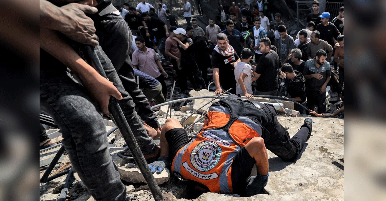 gaza-rescue-israel-attack A Palestinian civil defence member pokes his head through a hole carved in the concrete surface of a building while searching for survivors and the bodies of victims in the aftermath of Israeli bombardment in Khan Yunis in the southern Gaza Strip on November 8, 2023 amid the ongoing battles between Israel and the militant group Hamas. Photo: AFP/ Mahmud Hams