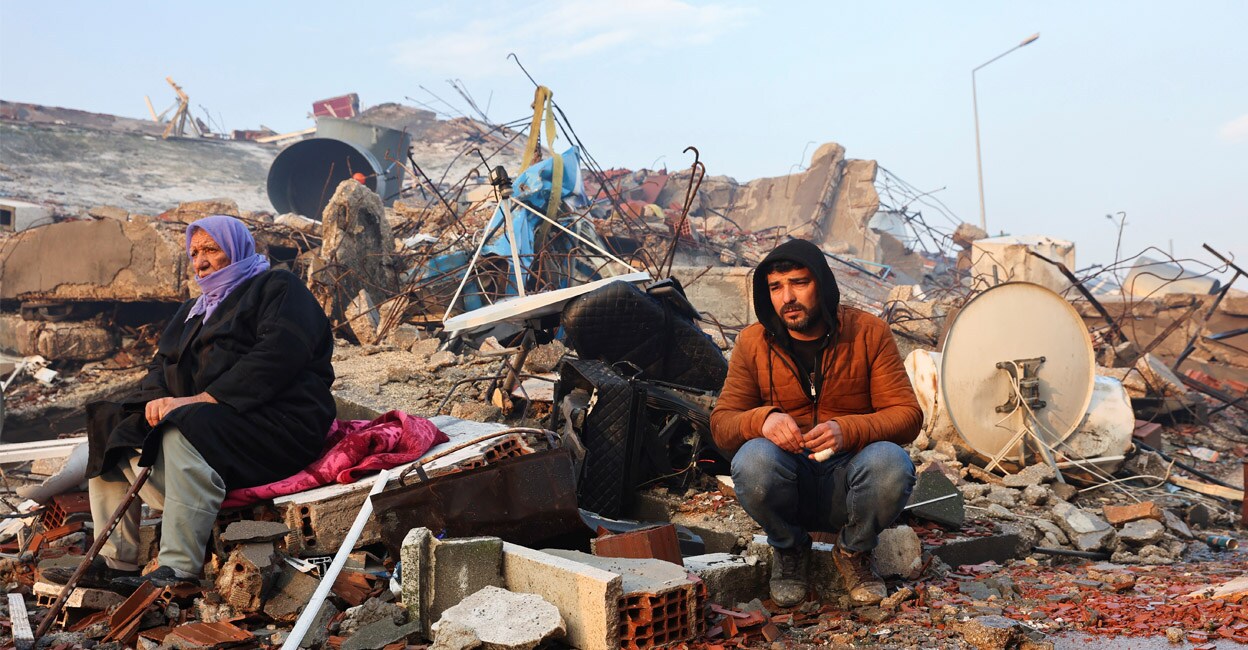 turkey-add-3 People sit amid rubble following an earthquake in Hatay, Turkey, on Tuesday. Photo: REUTERS/Umit Bektas