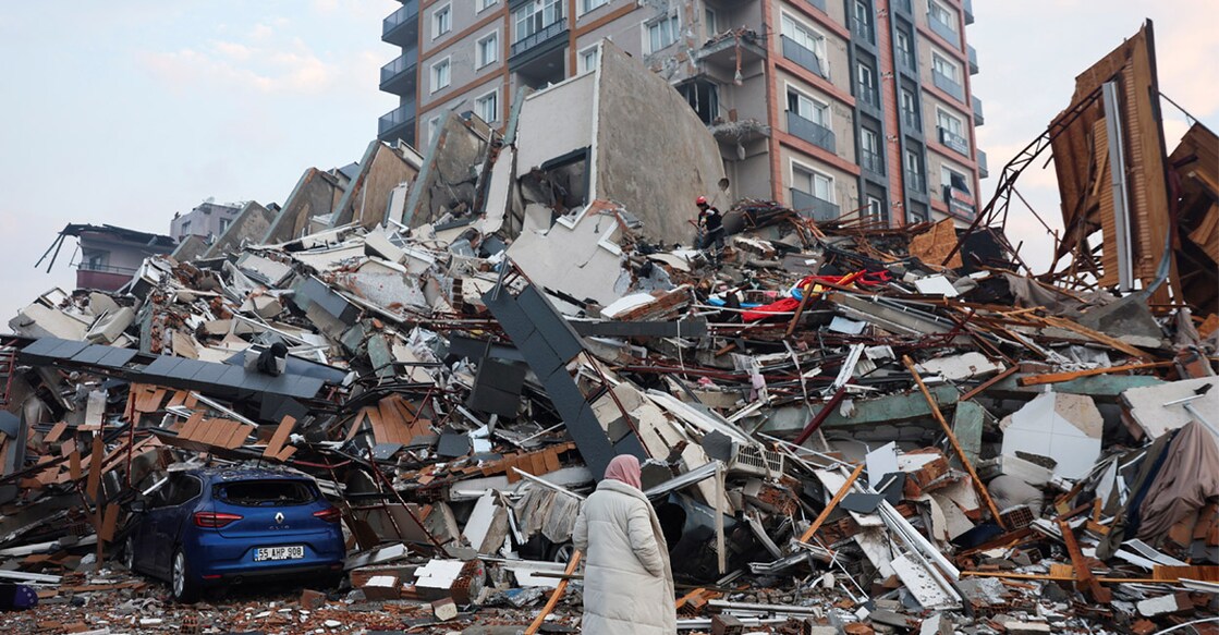 A woman looks on as rescuers search for survivors under the rubble following an earthquake in Hatay, Turkey, on Tuesday. Photo: REUTERS/Umit Bektas