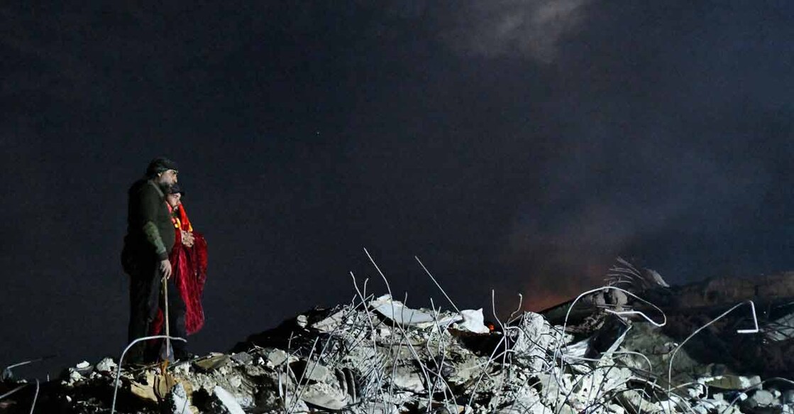 Syrian civilians watch as rescuers work at the rubble of a collapsed building late on February 7, 2023, in the town of Jindayris, as search and rescue operations continue following a deadly earthquake. Photo: AFP/ Rami al Sayed 