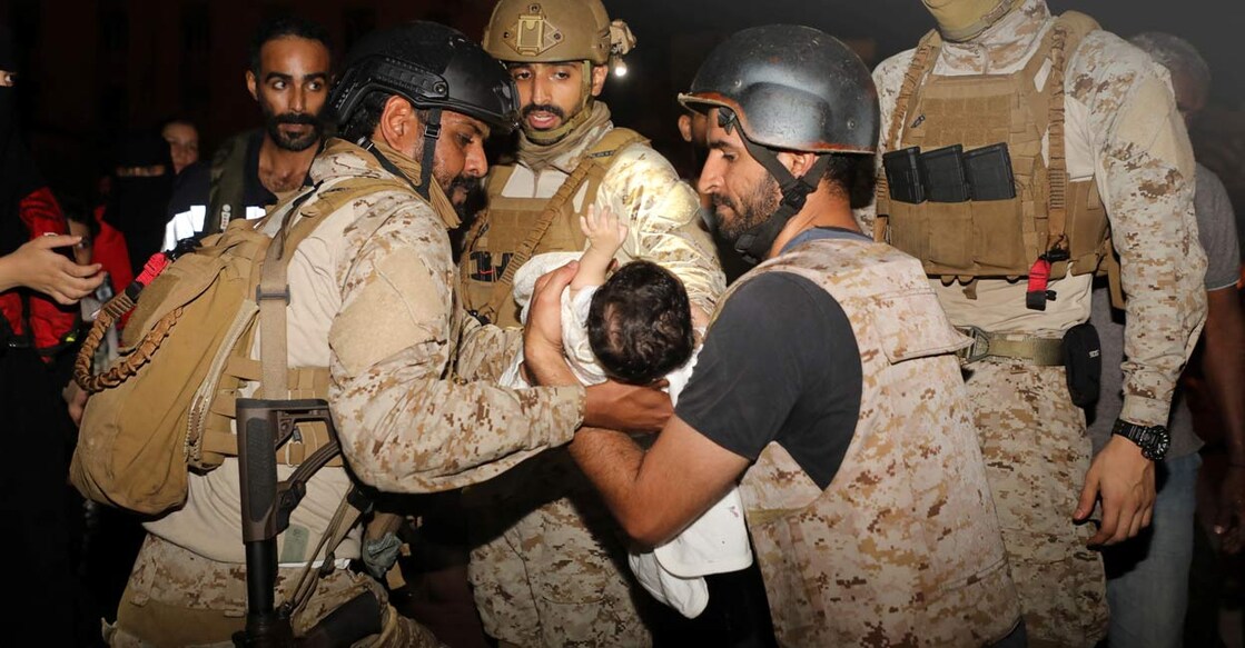 Saudi Royal Navy officers assist a child onboard their navy ship as they evacuate Saudis and other nationals are through Saudi Navy Ship from Sudan to escape the conflicts, Port Sudan. Photo: Saudi Ministry of Defense/Handout via REUTERS