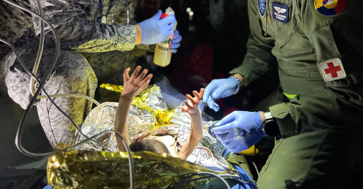 This handout picture released by the Colombian Presidency shows members of the Colombian Army checking one of the four Indigenous children who were found alive after being lost for 40 days in the Colombian Amazon rainforest following a plane crash in Bogota on June 10, 2023. Photo: AFP