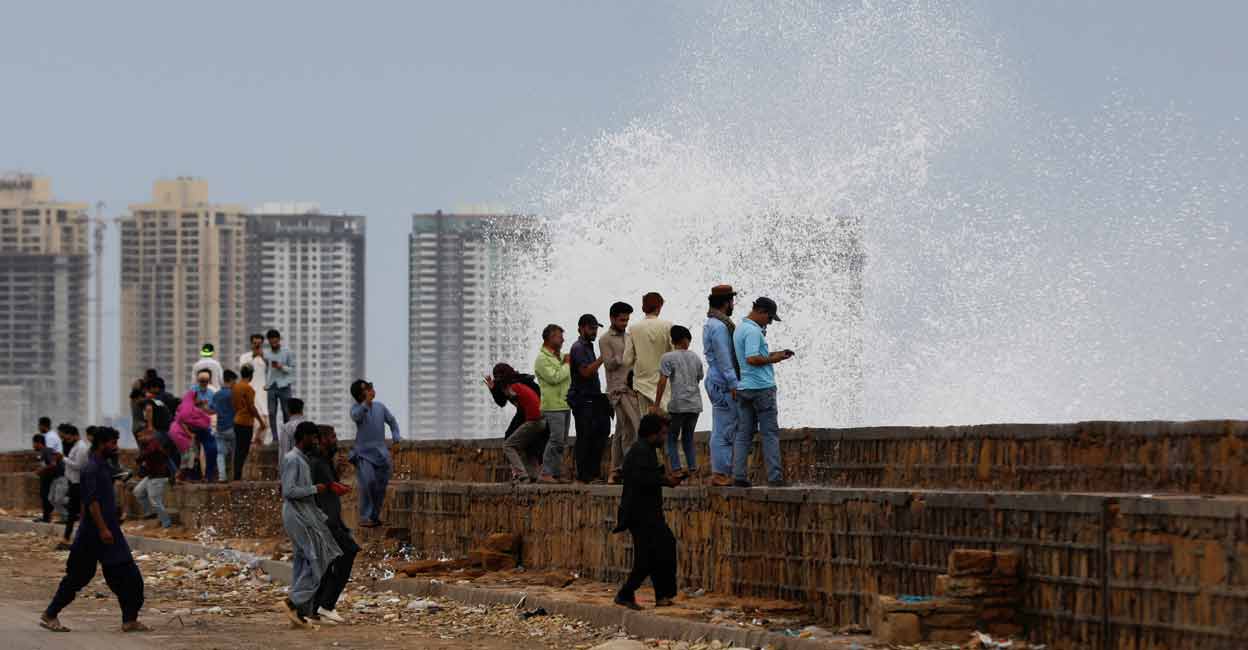 ASIA-WEATHER-INDIA-PAKISTAN People gather near the rising waves, before the arrival of the cyclonic storm, Biparjoy, over the Arabian Sea, at Clifton Beach, in Karachi, Pakistan June 13, 2023. Photo: REUTERS/Akhtar Soomro