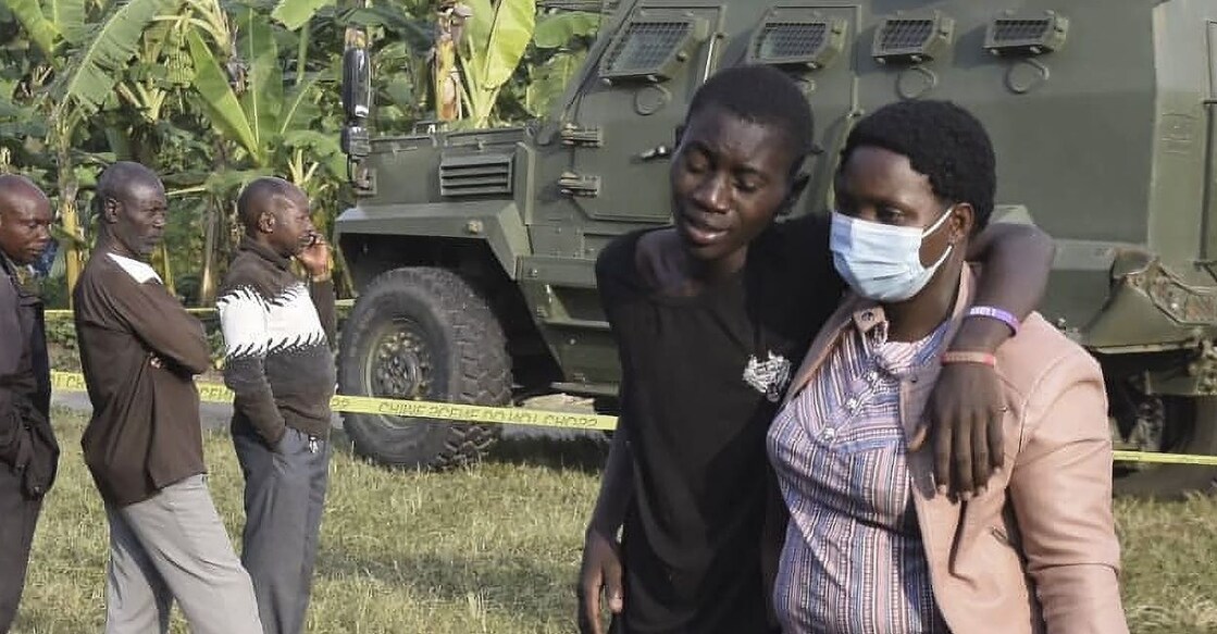 A boy is comforted at the scene of an attack in Mpondwe, Uganda, on June 17, 2023, at the Mpondwe Lhubiriha Secondary School. Photo: AFP