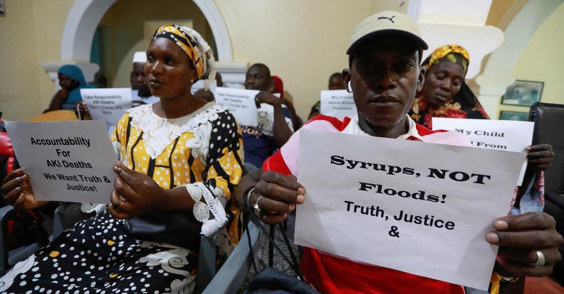 Parents hold up signs during a news conference, calling for justice for the deaths of children linked to contaminated cough syrups in Gambia. Photo: Reuters/Edward McAllister
