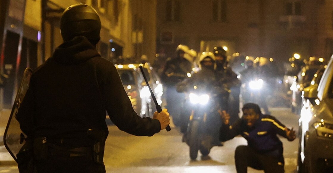 A person reacts while a police officer holds a baton during protests following the death of Nahel, a 17-year-old teenager killed by a French police officer in Nanterre during a traffic stop, in Paris, France, July 2, 2023. REUTERS/Nacho Doce