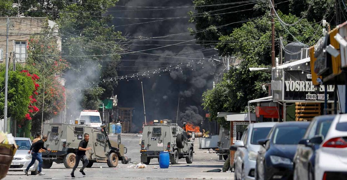 Palestinians run for cover during clashes with Israeli forces amid an Israeli military operation in Jenin, in the Israeli-occupied West Bank July 3, 2023. REUTERS/Raneen Sawafta
