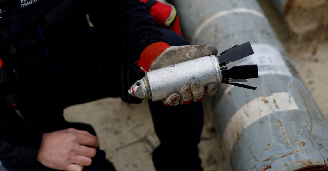 Ukrainian military serviceman Igor Ovcharruck holds a defused cluster bomb from an MSLR missile, among a display of pieces of rockets used by Russian army, that a Ukrainian munitions expert said did not explode on impact, in the region of Kharkiv, Ukraine. Photo: REUTERS