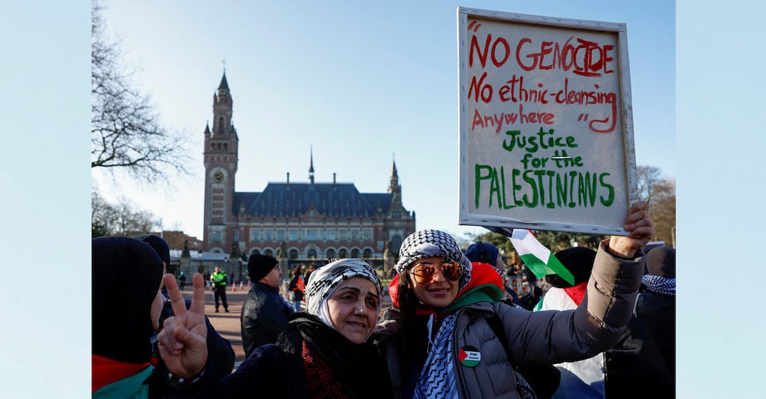 Pro-Palestinian protesters pose for a photo in front of the International Court of Justice (ICJ) as judges rule on emergency measures against Israel following accusations by South Africa that the Israeli military operation in Gaza is a state-led genocide in The Hague, Netherlands on Friday. Photo: Reuters/Piroschka van de Wouw