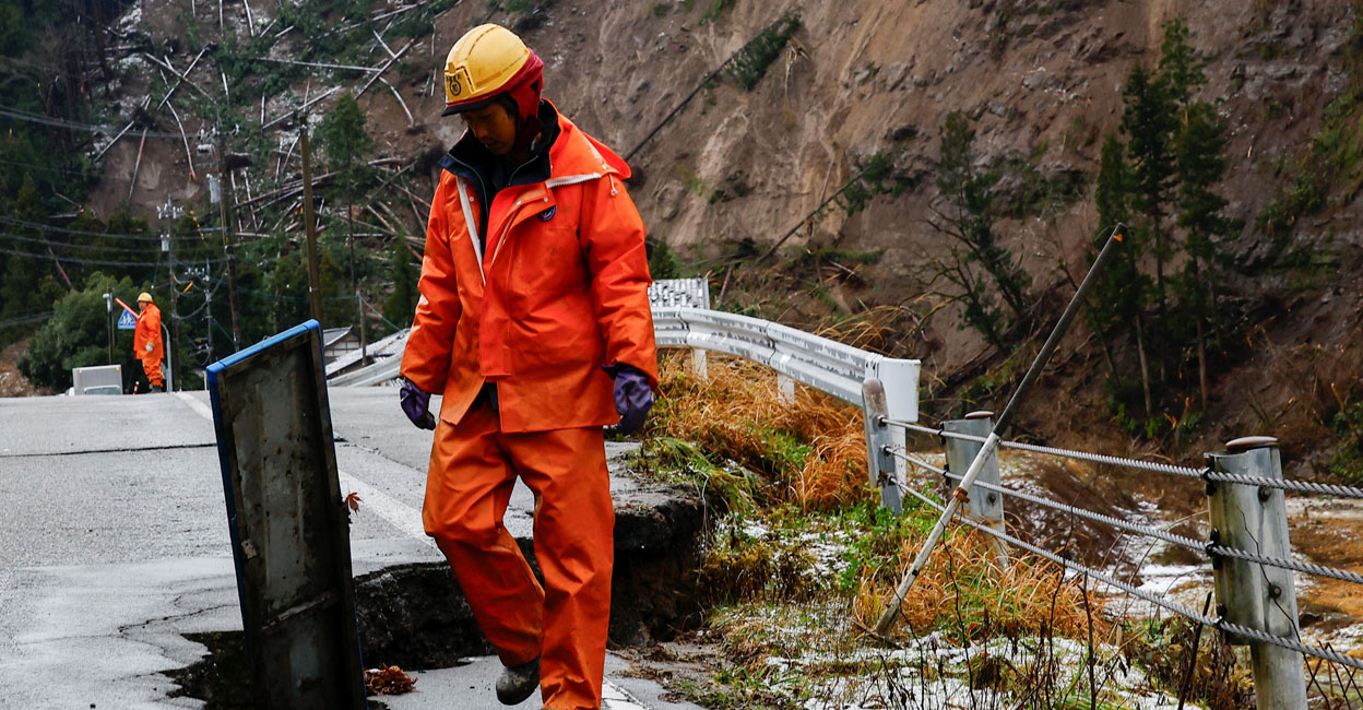 A worker guides vehicles in an area damaged by an earthquake and landslide in Wajima, Ishikawa Prefecture, Japan. Photo: Reuters