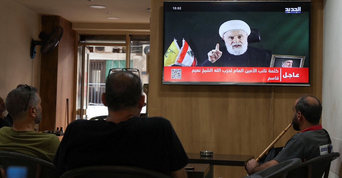 People watch Hezbollah deputy leader Sheikh Naim Qassem delivering a televised address, as they sit in a cafe in Beirut, Lebanon on October 15, 2024. Photo: Reuters/Mohamed Azakir